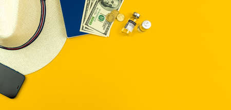 Safe travel flat lay background with vaccine vials, straw hat, passport and money, top viewの写真素材