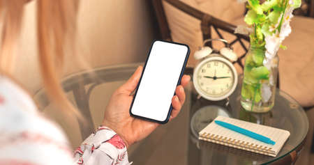 Feminine smartphone mockup, woman hold smartphone with blank white screen, beautiful and elegant backgroundの写真素材