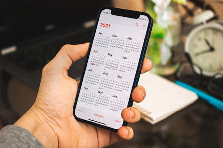 Kharkov, Ukraine - April 27, 2021: Man hold Apple iPhone 12 with Calendar app on the screen, 2021 calendar close up on the screenのeditorial素材
