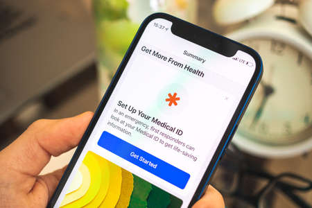 Kharkov, Ukraine - April 27, 2021: Man uses Apple iPhone with Medical ID app, man hold smartphone close-upのeditorial素材