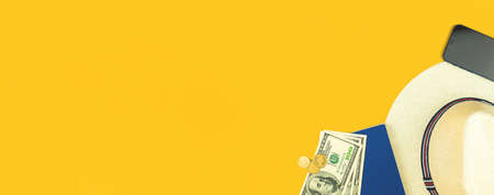 Summer and travel flat lay background, straw hat, documents, money and smartphone on yellow table, copy space, desktop for holiday and vacation concept, top viewの写真素材