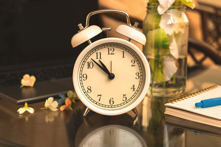 Alarm clock morning background in warm tones, cozy workplace concept photo