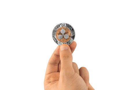 One ripple coin on hand isolated on white background, cryptocurrency