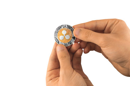 Male hand holds one ripple coin cryptocurrency isolate on white background photo