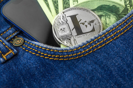 Litecoin business background, silver crypto coin in a pocket of blue jeans against US american...