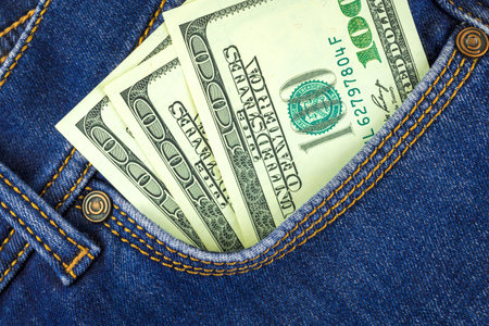 100 dollar banknotes in blue jeans pocket close up, business and finance background concept
