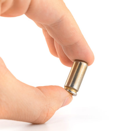 Man holds 9mm bullet in hand isolated on white background