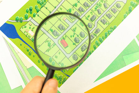 Man searching for real estate concept photo, property search background with a map and magnifying...