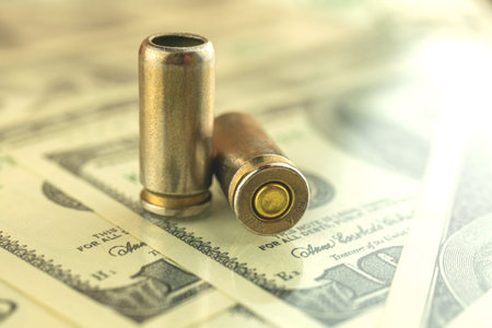 Criminal money background with dollar banknotes and bullet for gun, 9mm cartridge for pistol, mafia...
