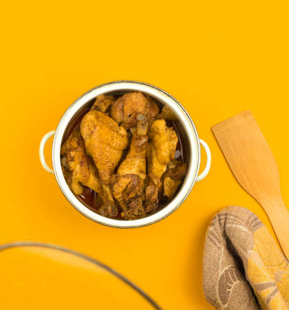 Roasted chicken in a saucepan, kitchen workspace workplace concept, flat lay colorful background with copy space, top viewの写真素材