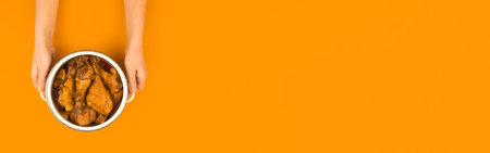 Banner saucepan with roasted chichen in a woman hand, dish and meal for a family and dinner, orange...