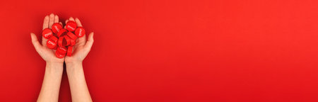 Kharkov, Ukraine - May 16, 2021: Lot of Coca-cola caps in hand banner with red background and copy...