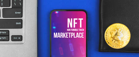 Banner NFT crypto art marketplace, modern mobile phone with logo and office desk with laptop, blockchain and cryptocurrency concept, top viewの写真素材