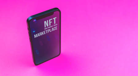 Concept of NFT marketplace on the mobile phone, smartphone with crypto art store, NFT non-fungible tokens, logo displayed on the screen, pay for unique collectibles in games or artの写真素材