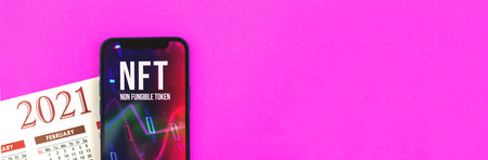 NFT non fungible token, crypto art 2021 concept, banner with pink background, calendar and modern mobile phone, future of art market, cryptocurrencyの写真素材