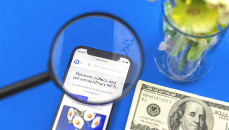 Kharkov, Ukraine - May 27, 2021: Opensea marketplace for NFT crypto art visual art with crypto payment, blockchain innovation concept, mobile phone with website and magnifying glassのeditorial素材