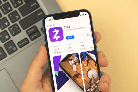 Kharkov, Ukraine - May 28, 2021: Man hold and use Zelle app on Apple iPhone screenのeditorial素材