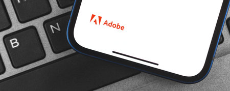 Kharkov, Ukraine - May 28, 2021: Adobe logo banner on the screen of mobile phone, background of...