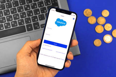 Kharkov, Ukraine - May 28, 2021: Man hold mobile phone with the Salesforce app title screenのeditorial素材