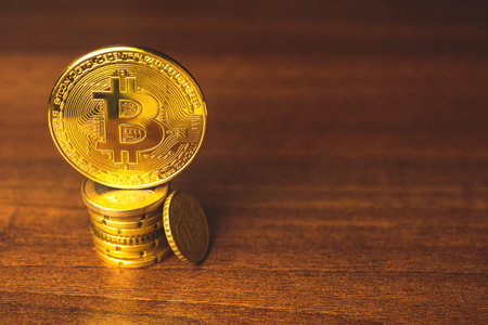 Golden bitcoin coin on a cents coins, wooden background of businessman, copy space photo