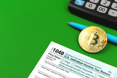 Taxes and bitcoin background, office desktop with the calculator and cryptocurrency coinの写真素材