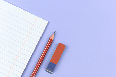 School notebook with pencil and eraser school composition backgorund on purple office table