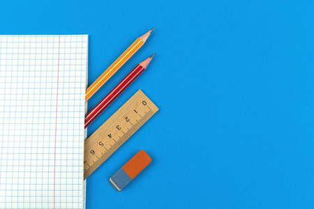 Prepare for the first school days concept composition, flat lay blue background with notebook, pencil, wooden ruler and eraser, copy space top view photoの写真素材