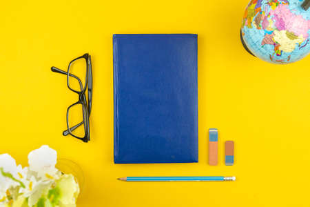 Back to school concept background and flat lay composition with blue diary or notebook, glasses and school stationery, top viewの写真素材