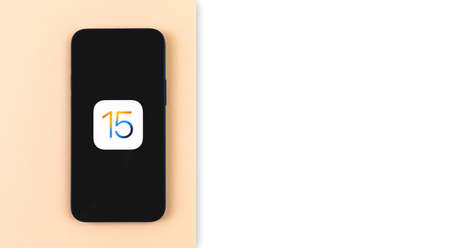 Kharkov, Ukraine - June 18, 2021: iOS15 logo displayed on the Apple iPhone 12, flat lay creative banner with copy space photoのeditorial素材