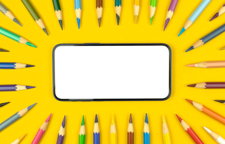 Study mockup background with modern mobile phone blank white screen and color pencils on the table...