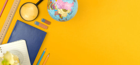 Geopgraphy lessons flat lay concept, back to school background, yellow table desktop top view with...