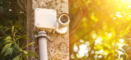 Outdoor CCTV monitoring, banner, security cameras with sunlight flare, sunsetの写真素材