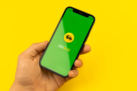Kharkov, Ukraine - July 2, 2021: Man using OnTaxi app, logo closeup