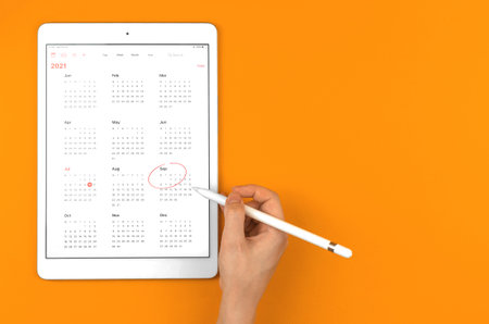 Calendar of 2021 september month, woman make red circle around the month, orange background photo