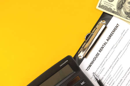 Townhouse rental agreement form. Office desktop with calculator, pen and money. Top view and copy spaceの写真素材