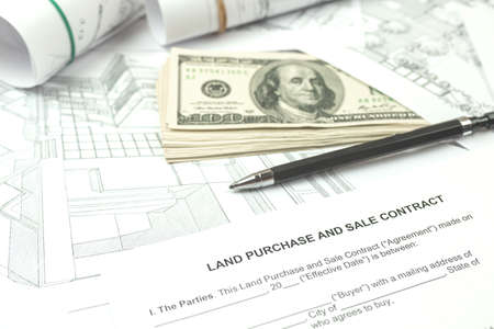 Construction of a building on a new plot of land according to architectural drawings, office desk background photoの写真素材