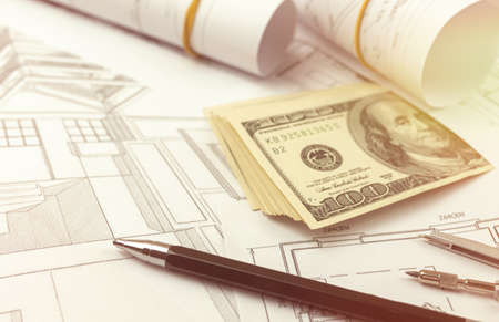 Construction and structure concept. Blueprints for architectual project, building and engineering. Office desktop with money and penの写真素材