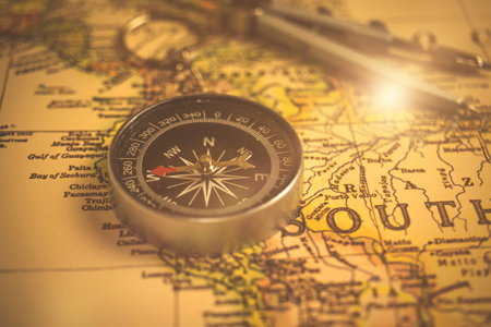 Brass antique compass on a old world map. Exploration concept backgroundの写真素材