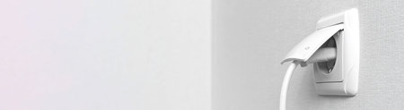 Banner with electrical plug in the electric socket on a wall, interior photo with copy