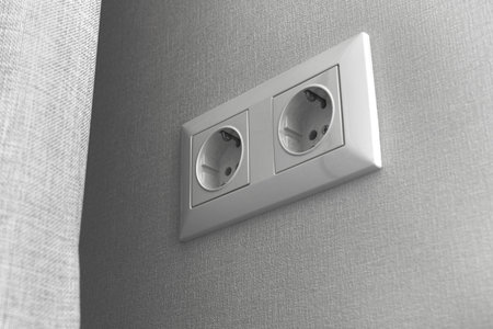 Double European electrical socket on wall at home in modern design, gray wall color