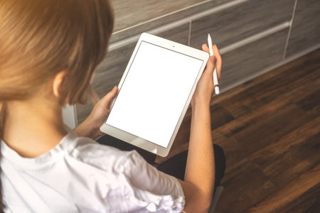 Young freelancer girl using digital tablet pc in hand with stylus pen, new apartment room background...