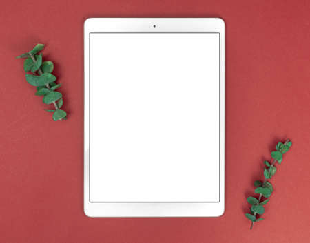 Flat lay feminine workspace with blank white screen tablet pc mockup, floral composition, copy spaceの写真素材