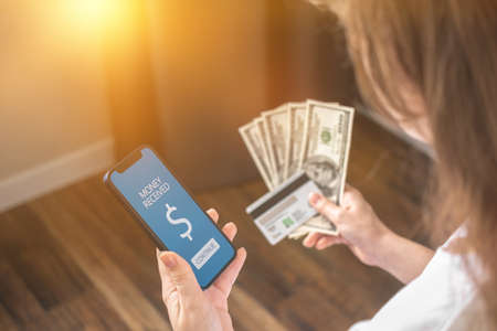 Mobile bankning concept, money received screen and credit card in woman handの写真素材