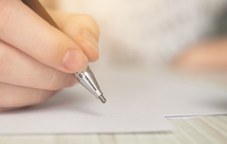 Close-up hand writing, on wooden table. Education, learning and document signing concept. Paperwork...
