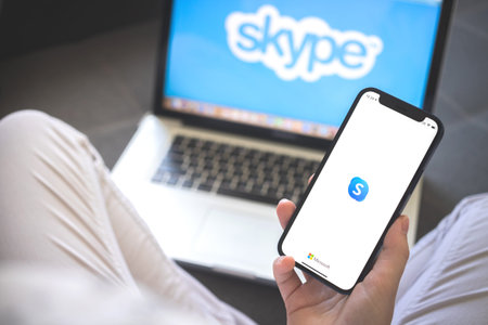 Kharkov, Ukraine - August 12, 2021: Skype app. Woman using smartphone with skype application. Brand