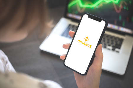 Kharkov, Ukraine - August 12, 2021: Binance app. Woman using smartphone with binance application. Brandのeditorial素材
