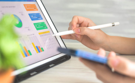 Businesswoman analyzing company perfomance on digital tablet using wireless stylus pen. Business and...