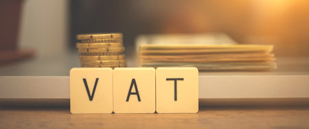 Banner VAT increase concept. Value added tax on wooden block cubes. Business desktop with laptop and money, management and investment backgroundの写真素材