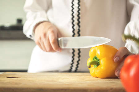 Young woman preparing yellow sweet bell pepper for healthy food conceptの写真素材