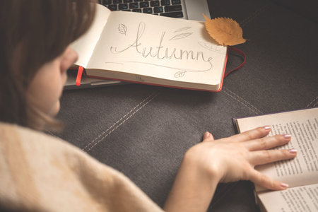 Young girl reading a book, fall season scene. Cozy home concept. Background with the diary, old book...